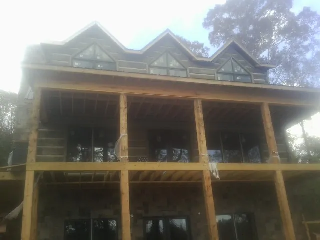 Dormers and porch framing on a large log home under construction — Roof Coating work by our crew in Pedricktown